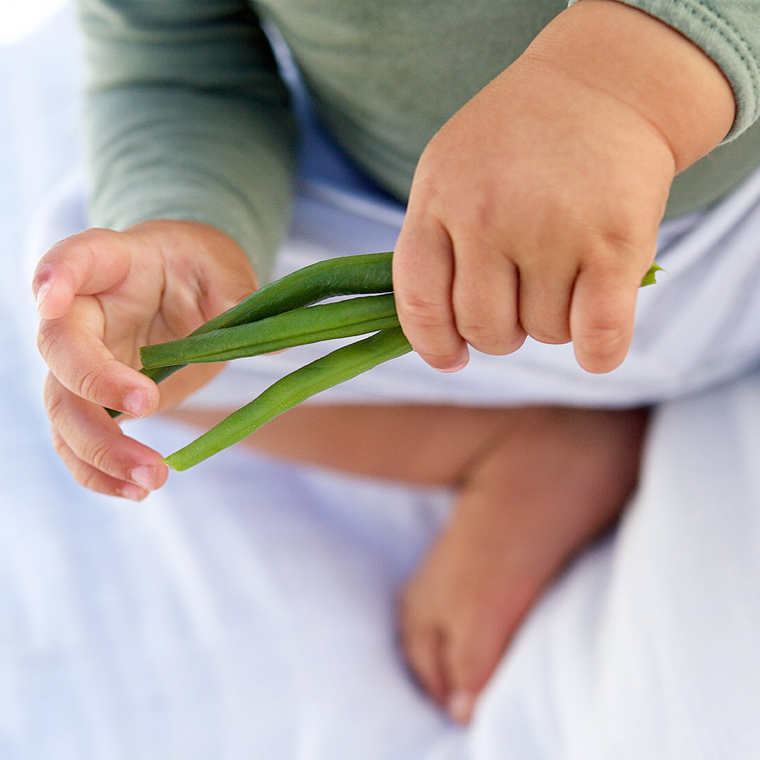 Banner baby holding greens