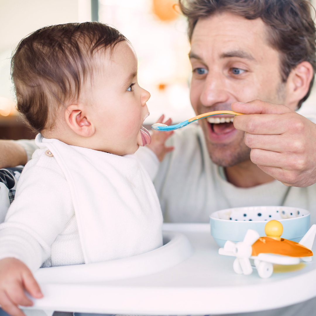 Banner smiling father feeding baby