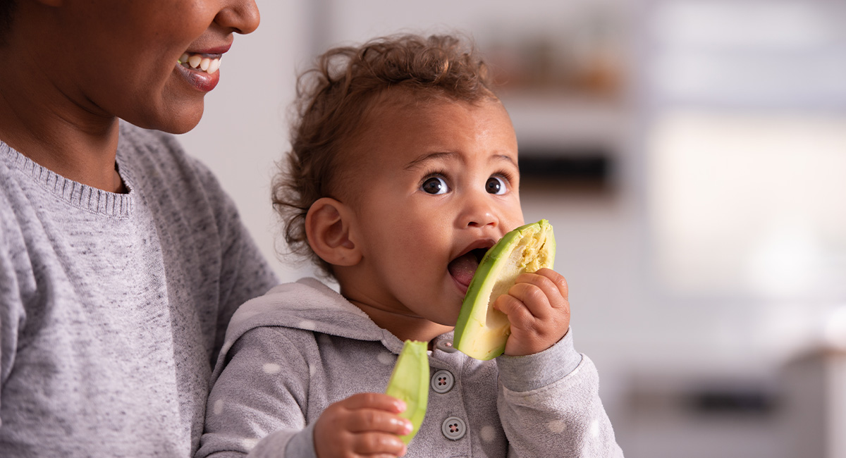Baby and mother with avocado