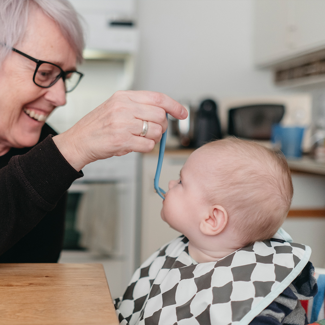 Grandmother feeding baby