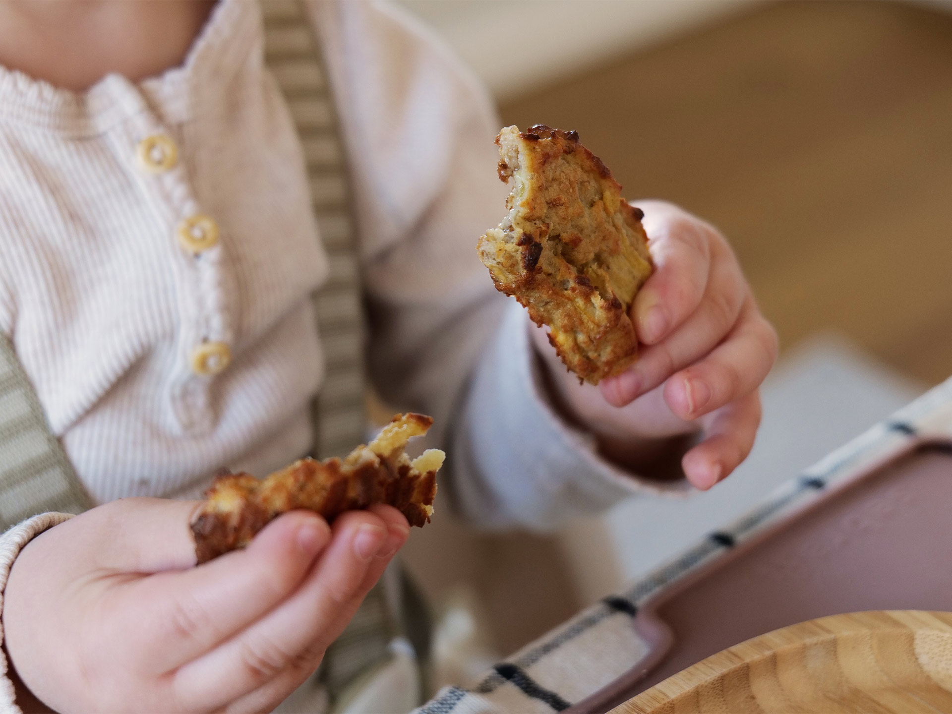 baby holding porridge sticks